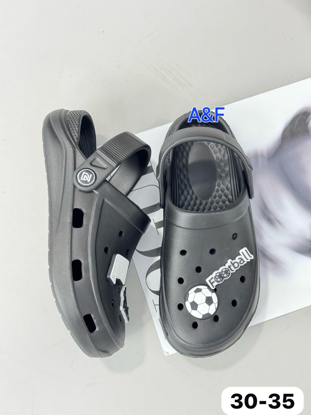 картинка Детские черные кроксы с футбольными украшениями 624436 от магазина Одежда+